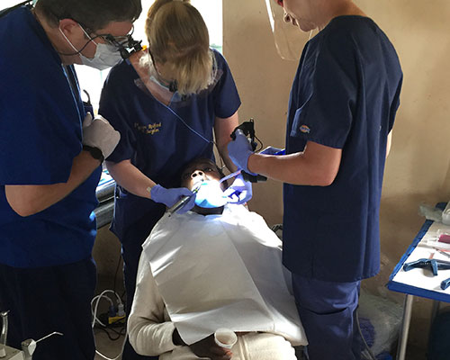 Dentists helping patient looking in patients mouth